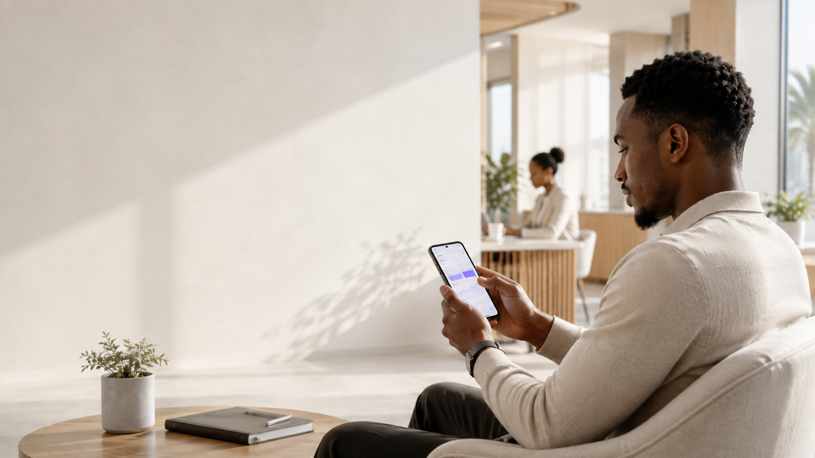 Utilisateur consultant une application mobile dans un environnement lumineux et contemporain.